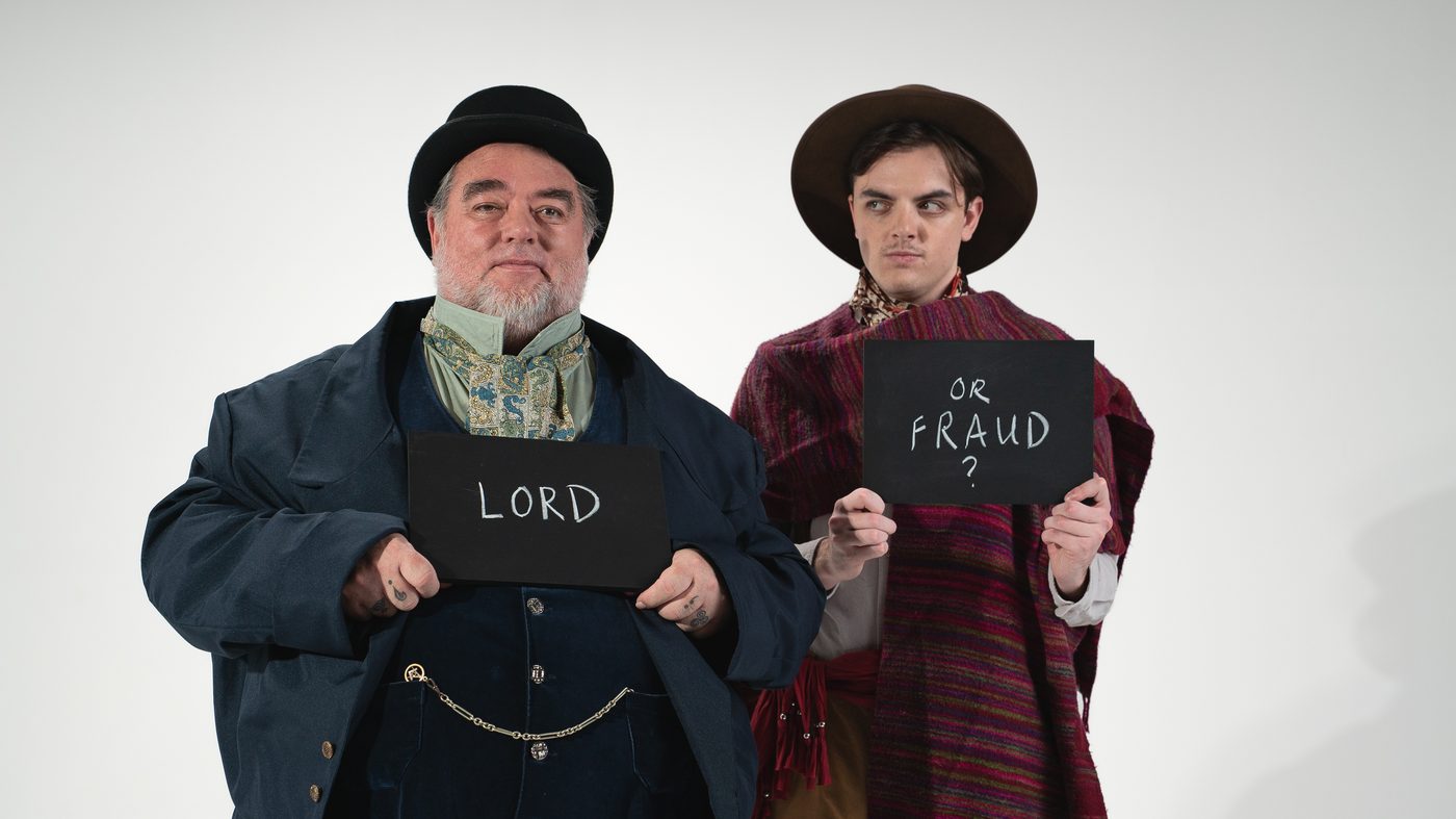 The Claimant and Roger Tichborne holding chalkboard signs reading LORD and OR FRAUD